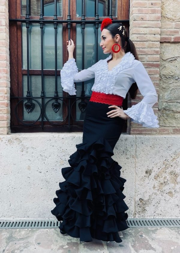 Chica con falda de flamenca negra con volantes y blusa elastica