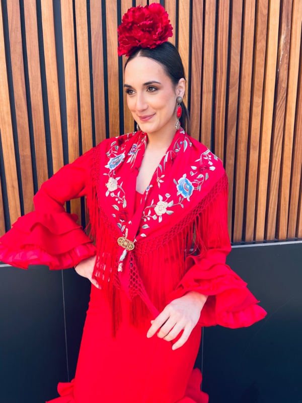 chica vestida de flamenca con mantoncillo bordado rojo